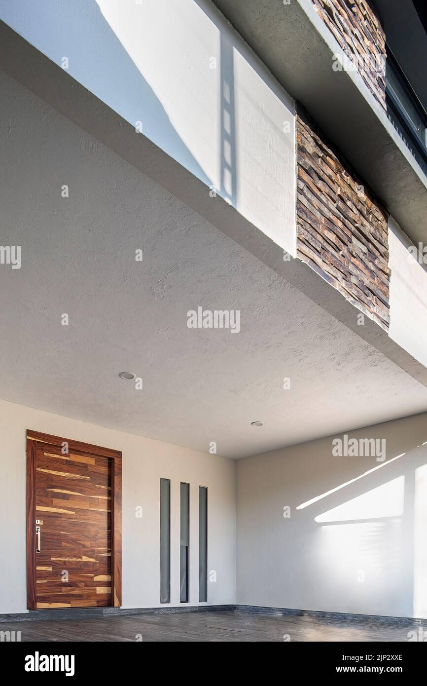 facade of a modern house with stone, staple that wraps the windows painted in gray, metal