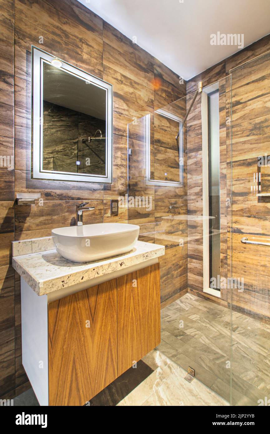 bathroom with luxury finishes, main mirror with led light from behind, white ceramic washbasin Stock Photo