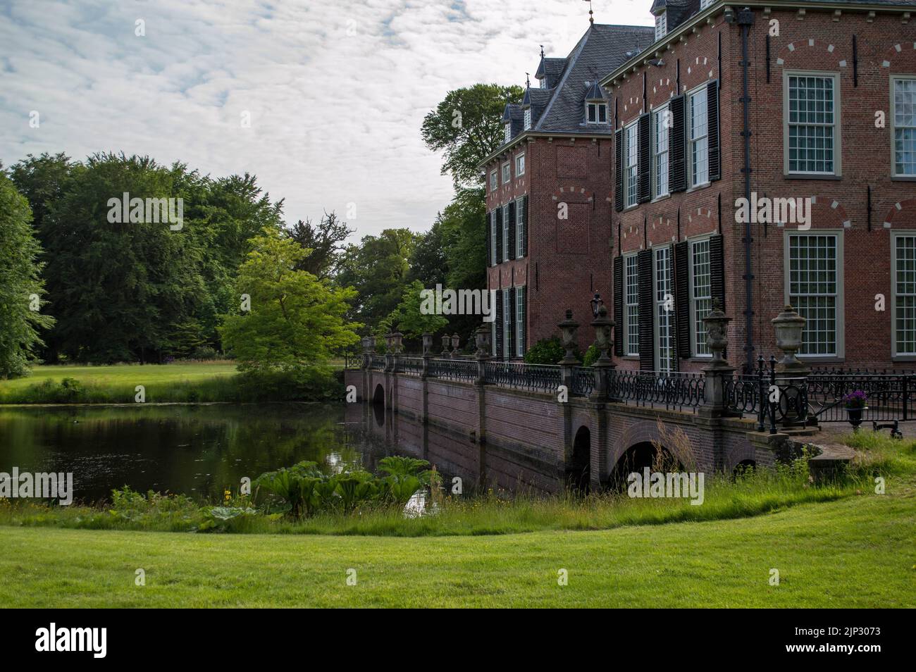The beautiful Duivenvoorde Castle in Voorschoten, the Netherlands, with a river in front and trees in the background Stock Photo