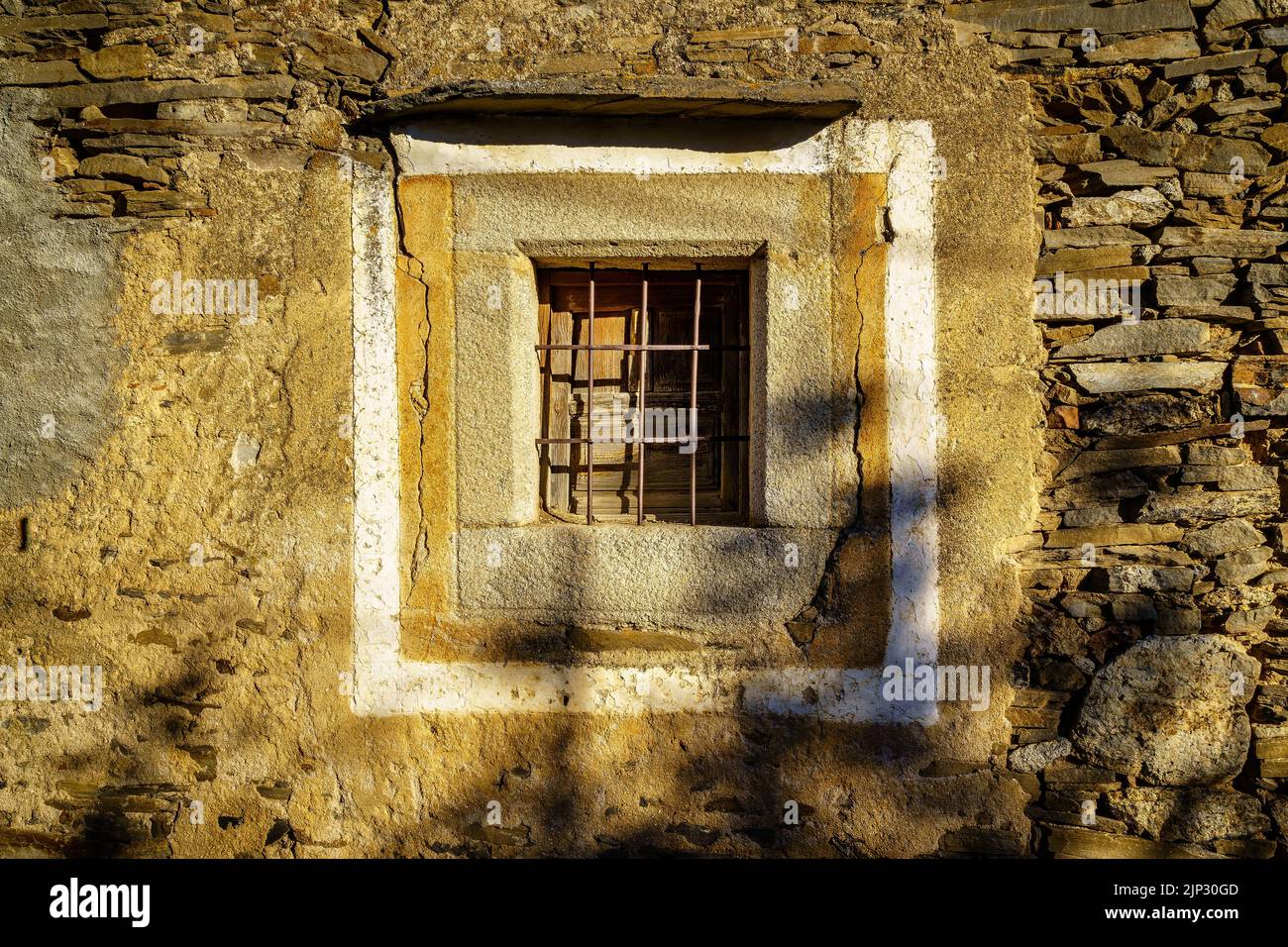 Old window in stone house on the sunny exterior. Spain. Stock Photo