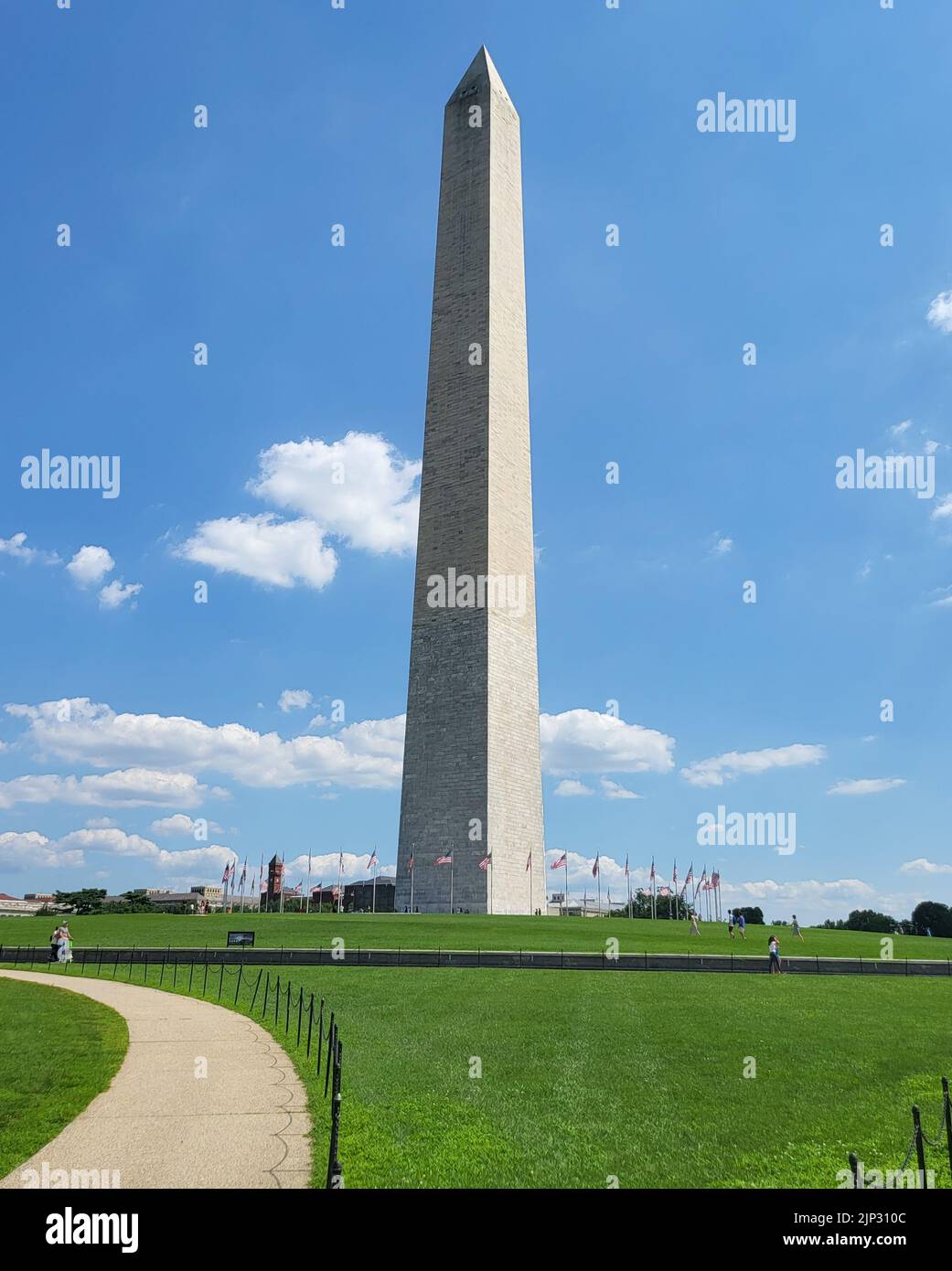 A vertical shot of the Washington monument from the side of the White House on a summer afternoon Stock Photo