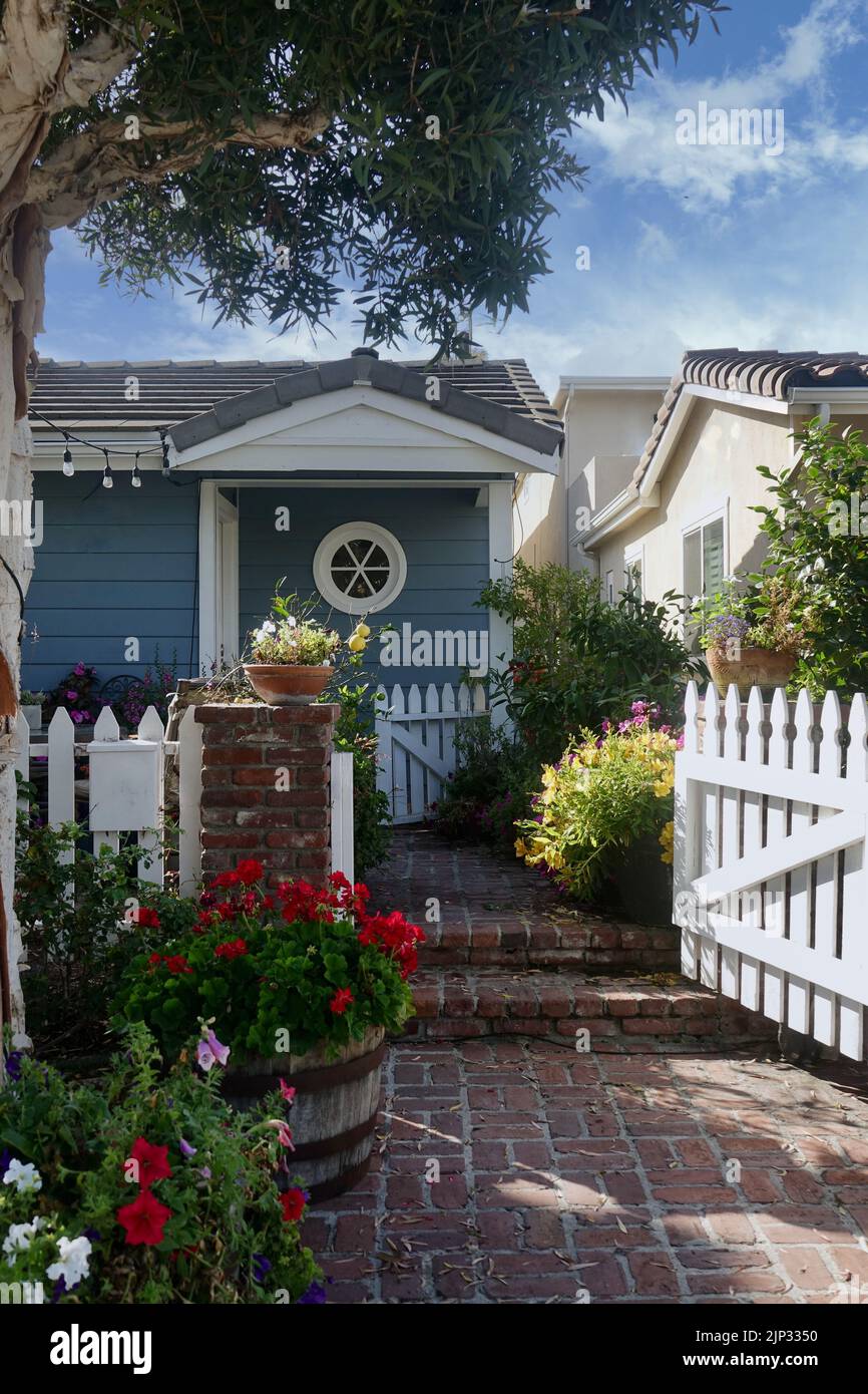 charming beach cottage with picket fence and brick walkway Stock Photo