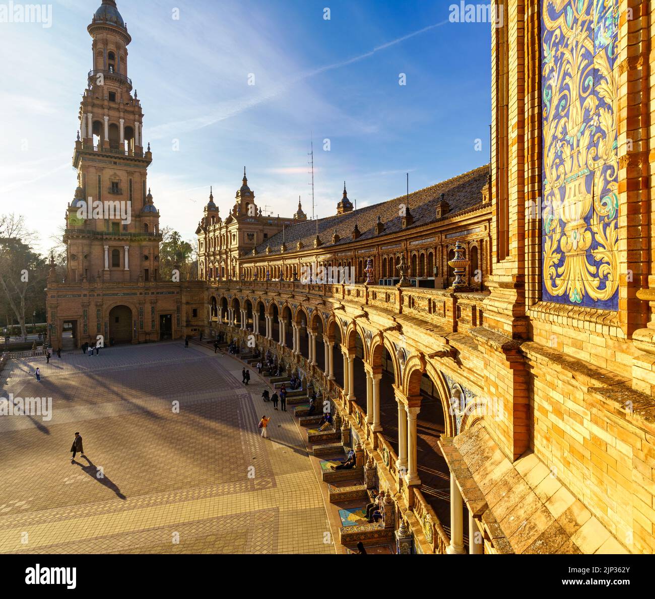 Plaza de España in Seville, sunny day with blue sky and white clouds at sunset on a summer day. Golden and orange tones. Andalusia. Stock Photo