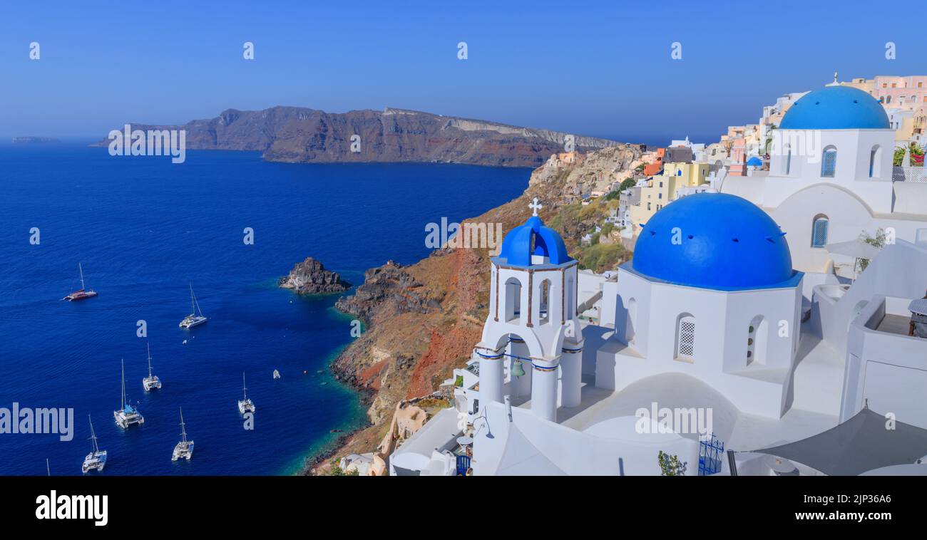 Santorini, Greece. Lovely view of Oia village with traditional famous blue domed church on the Caldera in the Aegean Sea. Stock Photo