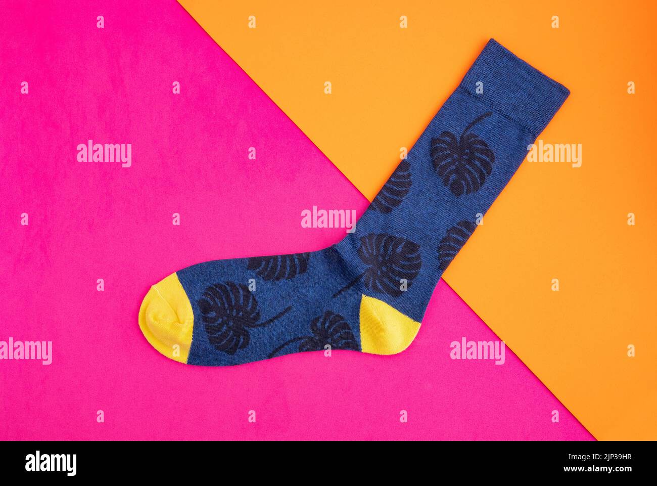 Long sock for men with monstera leaves in blue and yellow Stock Photo