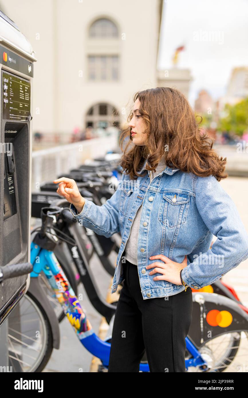 Young Woman Renting an ebike | Bicycle Rental | Transportation | Bike Rental | Unposed Portraits Stock Photo