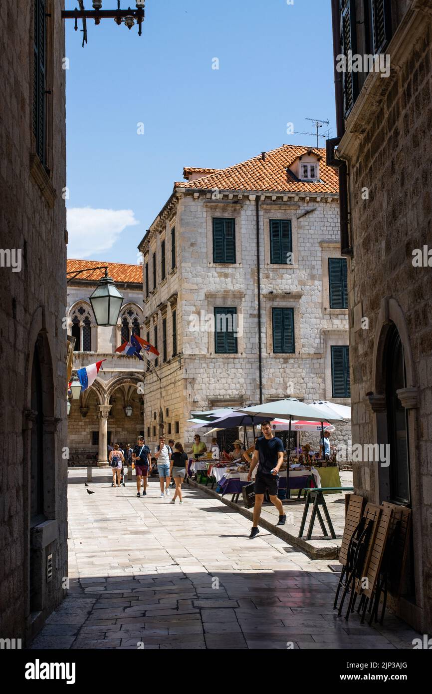 A vertical shot of people walking around the market in Dubrovnik during sunny summer day, Croatia Stock Photo