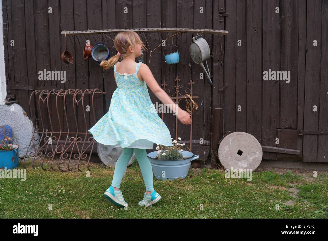 little girl is dancing in front of barn dress flying Stock Photo