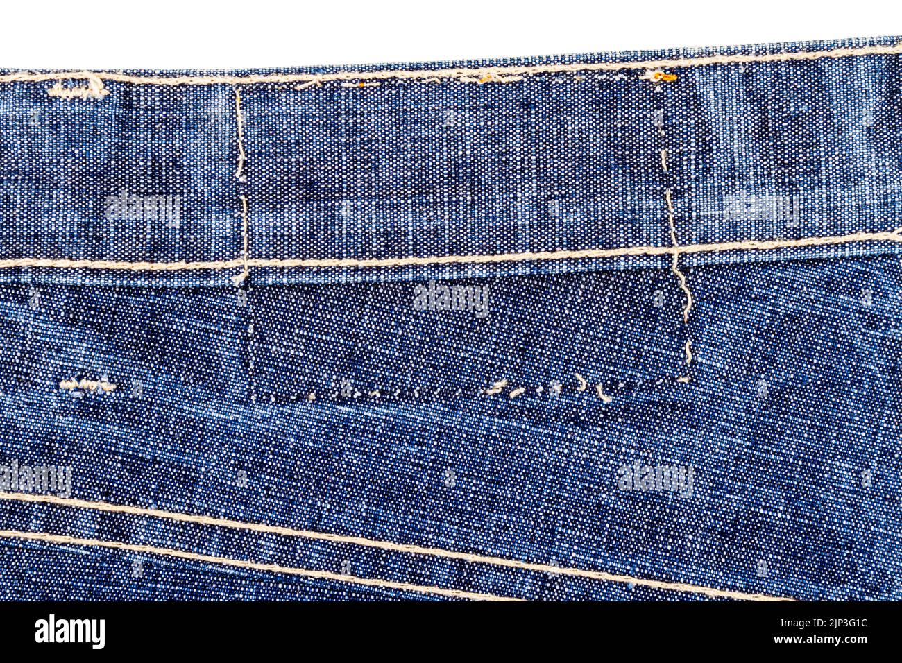 Piece of blue jeans fabric with a ripped of label isolated on white ...