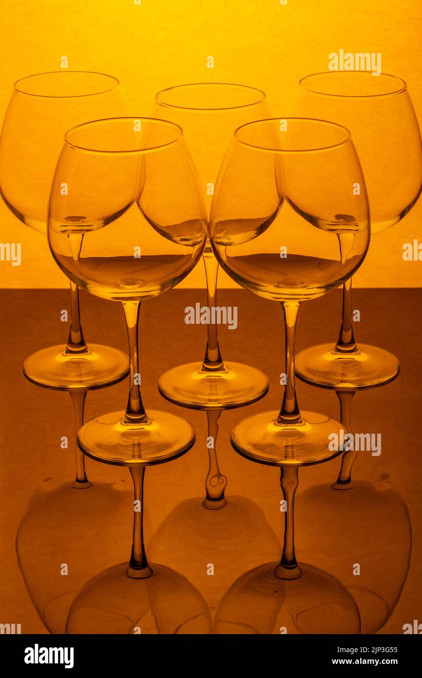 Still life with empty wine glasses on a reflective surface Stock Photo