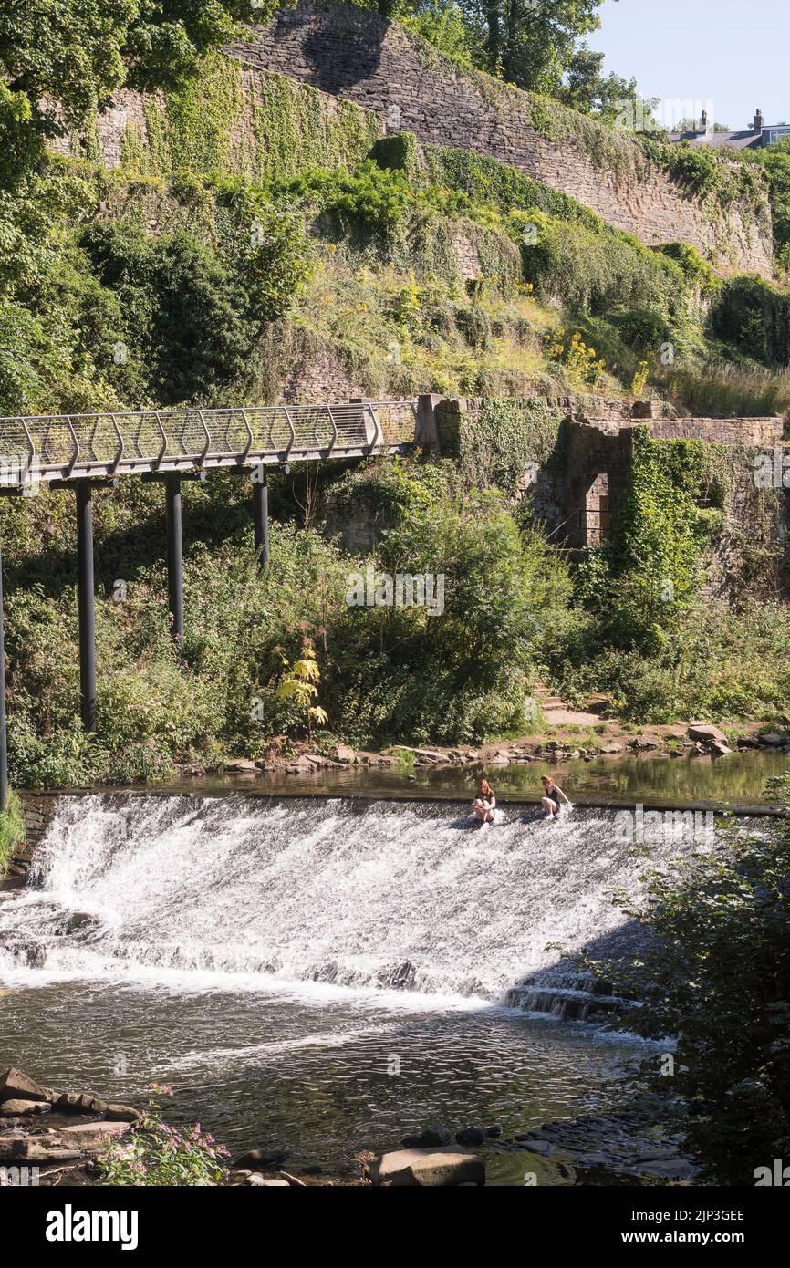 UK heatwave. Two young women cooling off in the river Goyt in New Mills, Derbyshire, England. Stock Photo