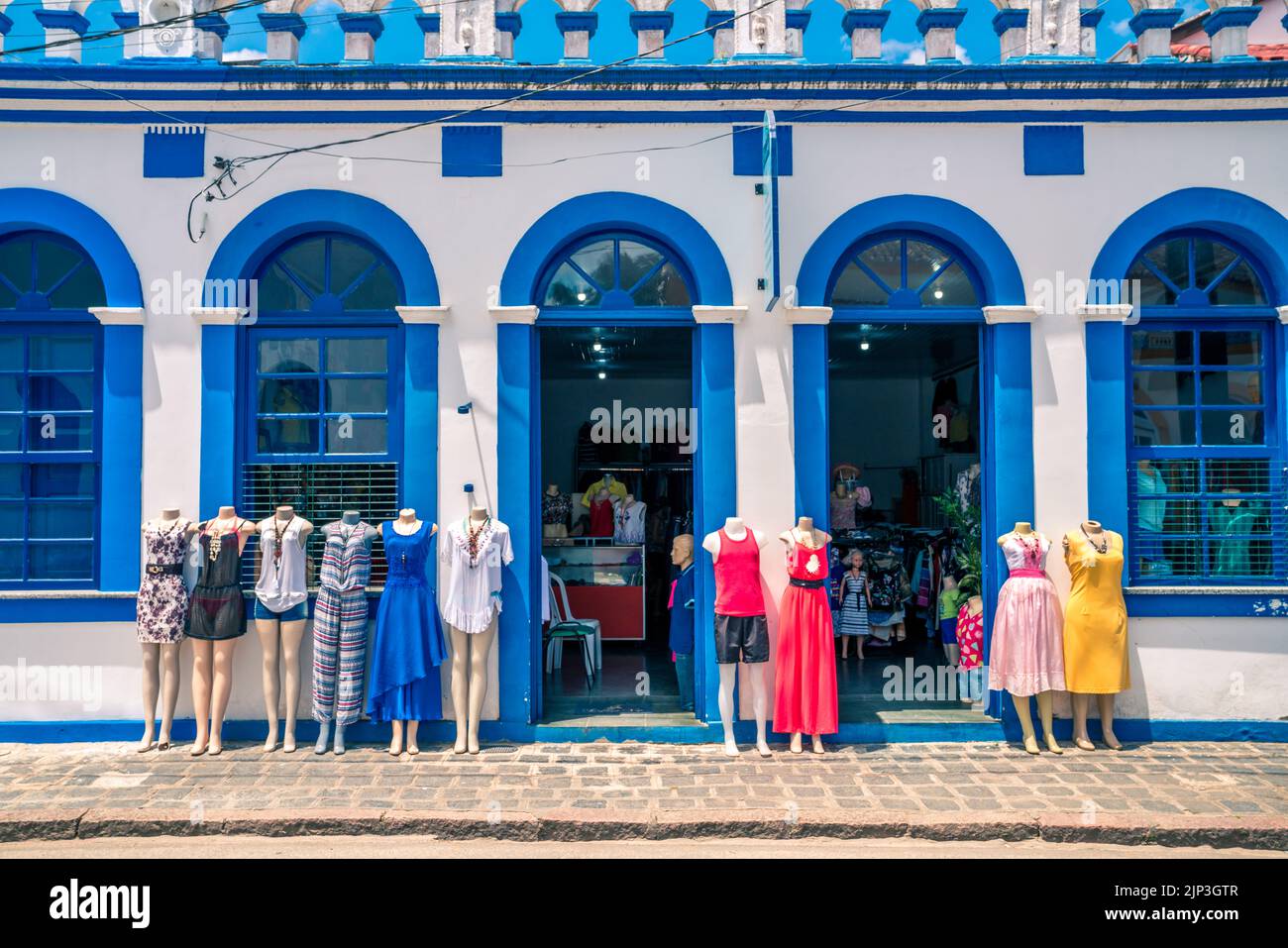 Facade of a clothing store with mannequins display on the sidewalk Stock Photo