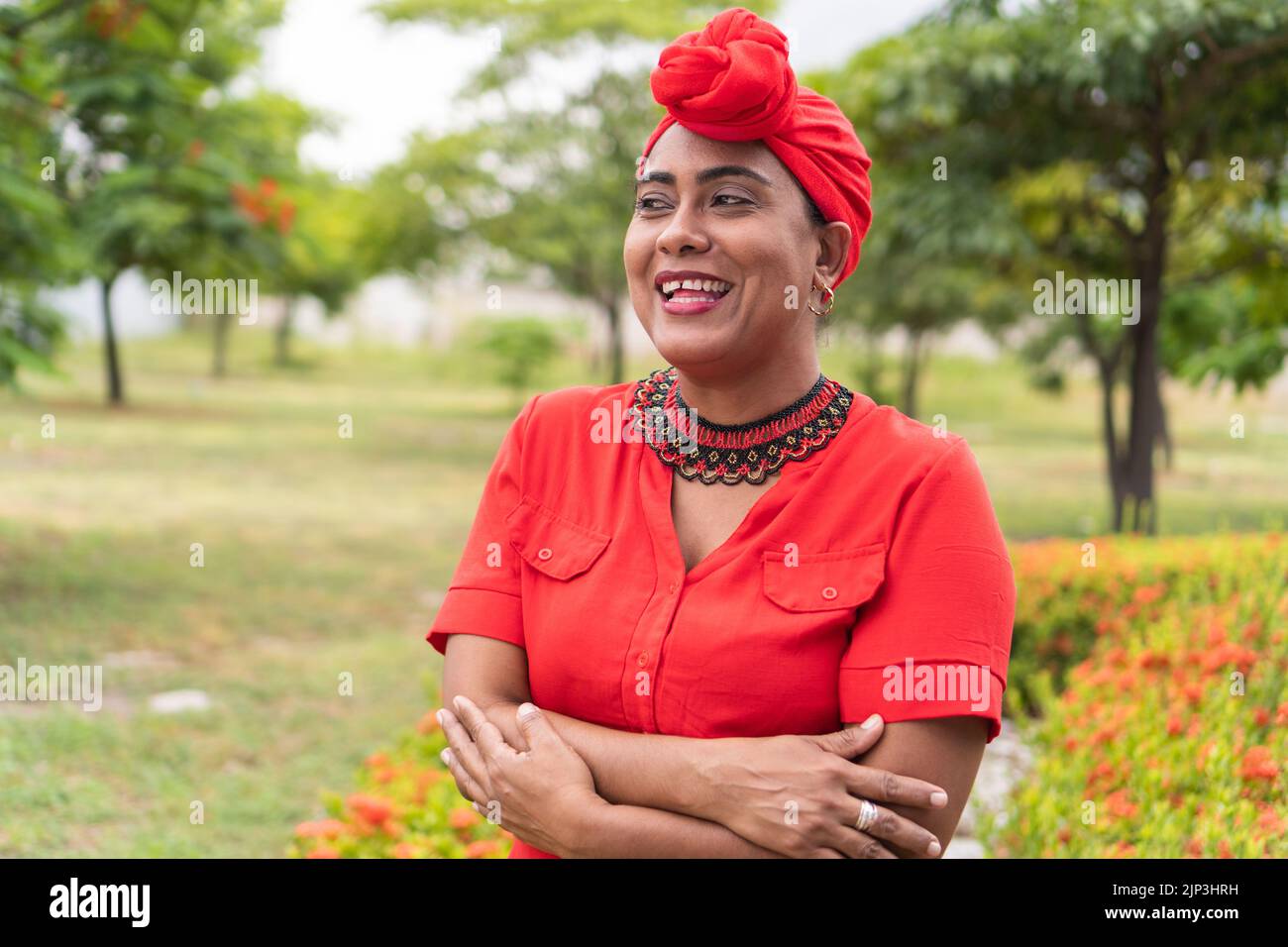 Positive afro lady smiling while standing in a park Stock Photo - Alamy