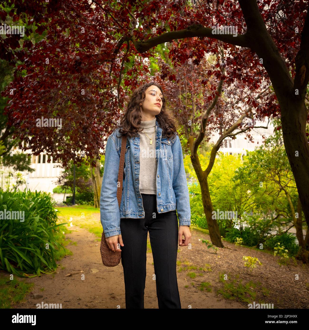 Unposed Portrait of Young Woman Walking in an Urban Park Setting | Red