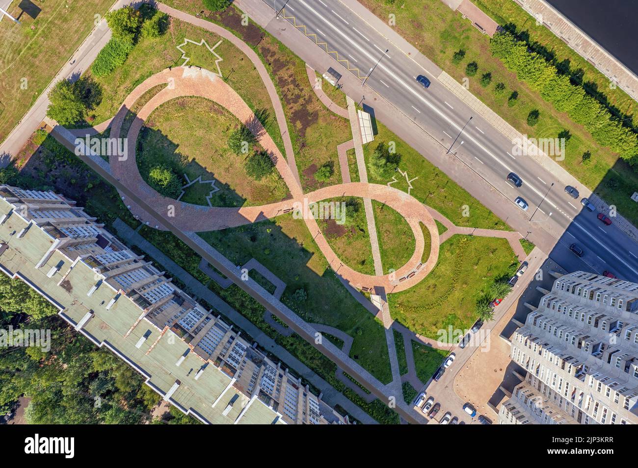 Paved eight shaped path road in the city courtyard at sunny day top aerial view. Beautiful green park in residential district top view Stock Photo