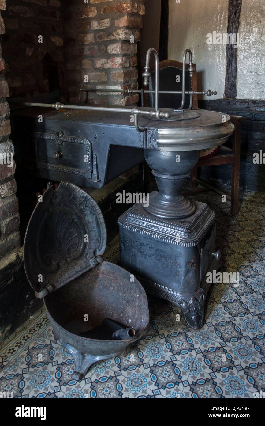 Vintage coal scuttle and antique Belgian / Flemish cast-iron coal stove / Leuvense stoof / Brabantse kachel / Mechelse stoof Stock Photo