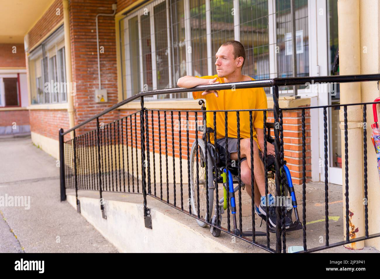 A disabled person in yellow dress in a wheelchair at school Stock Photo