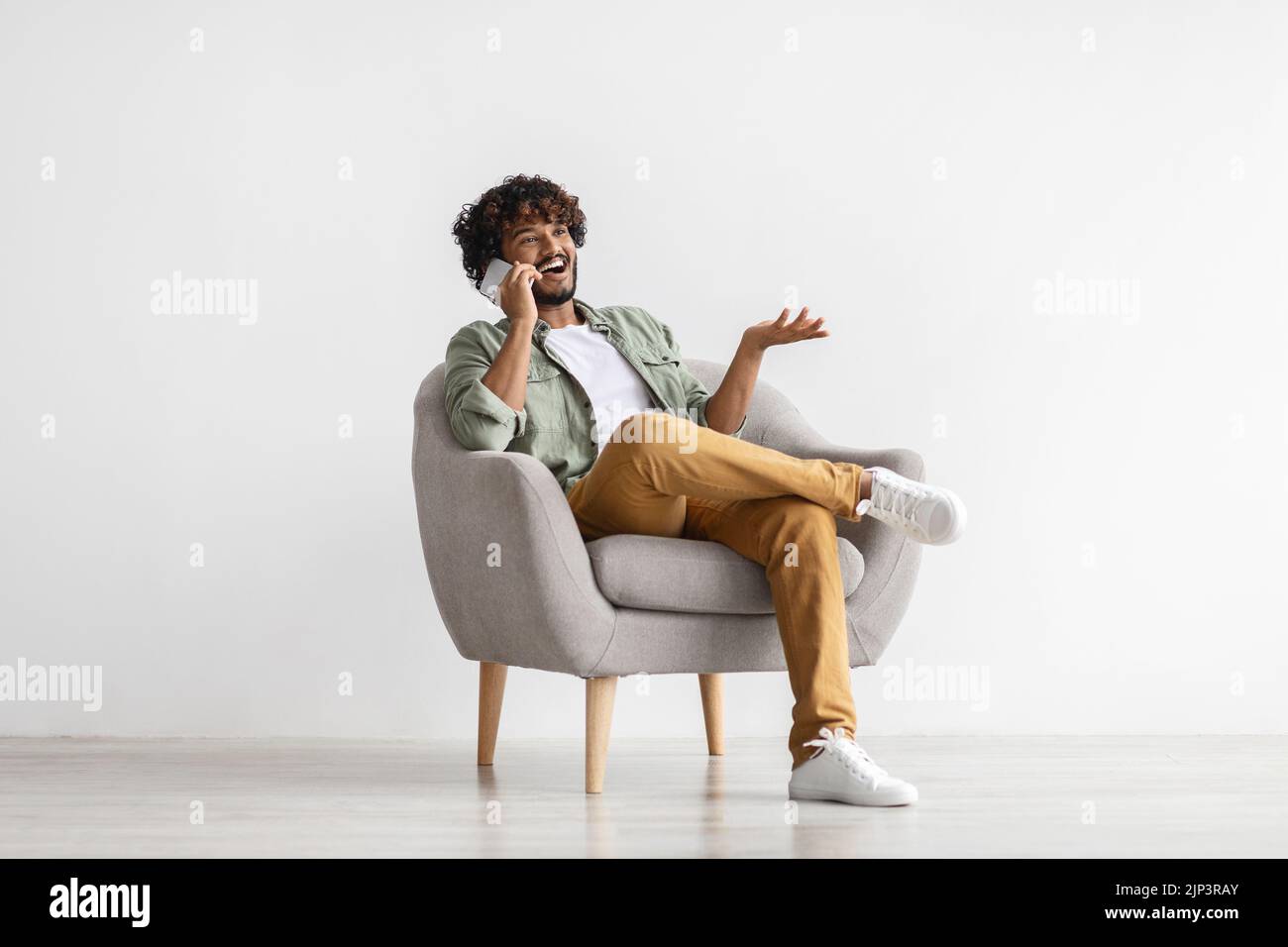 Cool eastern young man having phone conversation Stock Photo
