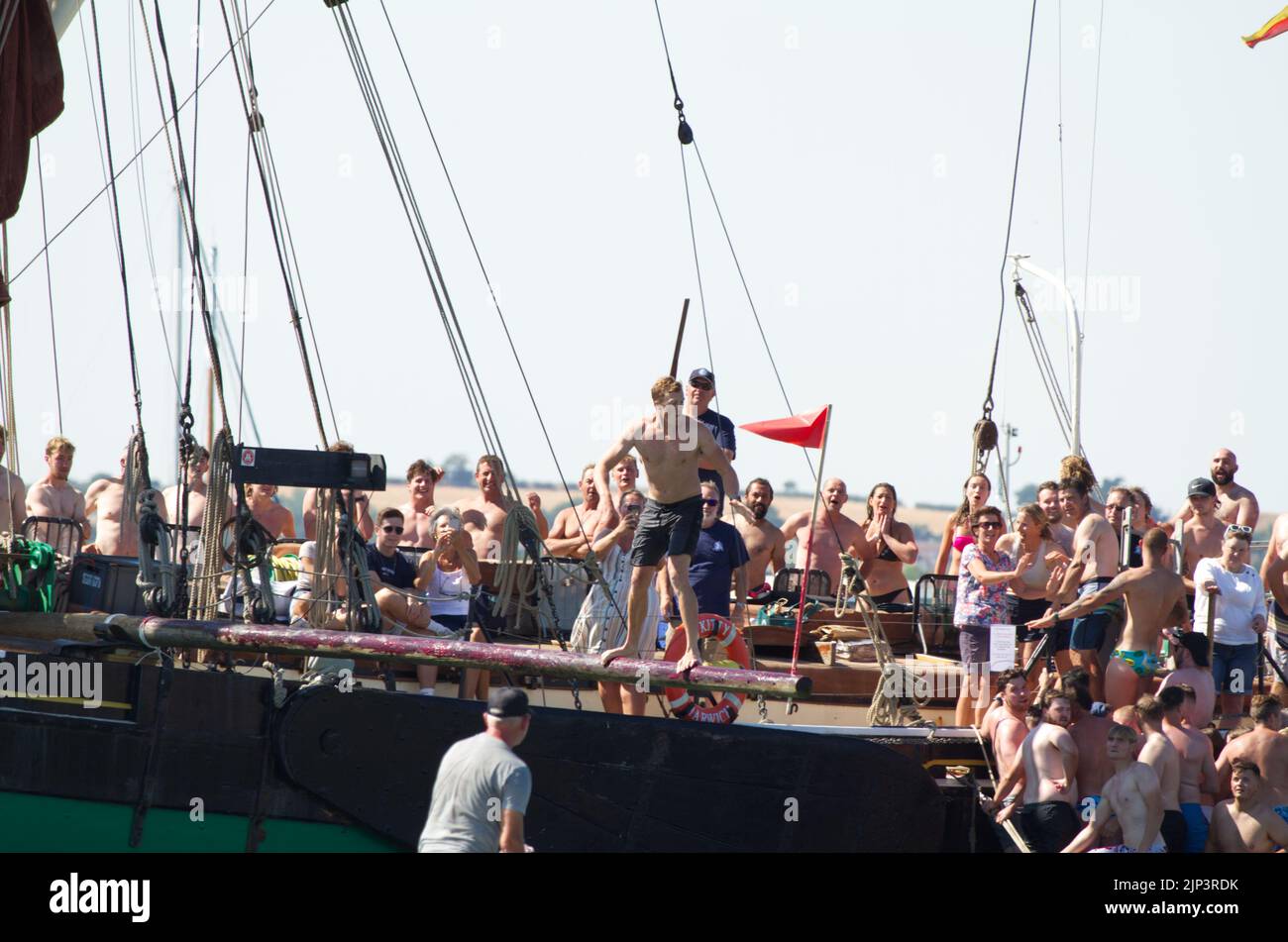 West Mersea Town Regatta on Mersea Island in Essex. Walking the greasy pole is traditionally the last event of the day. Stock Photo