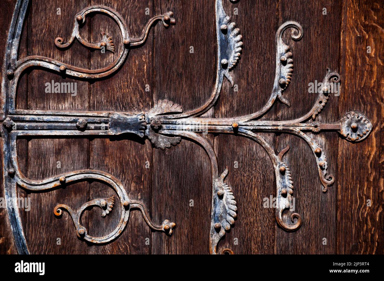 Decorative old wrought iron hinges on the Romanesque doorway of