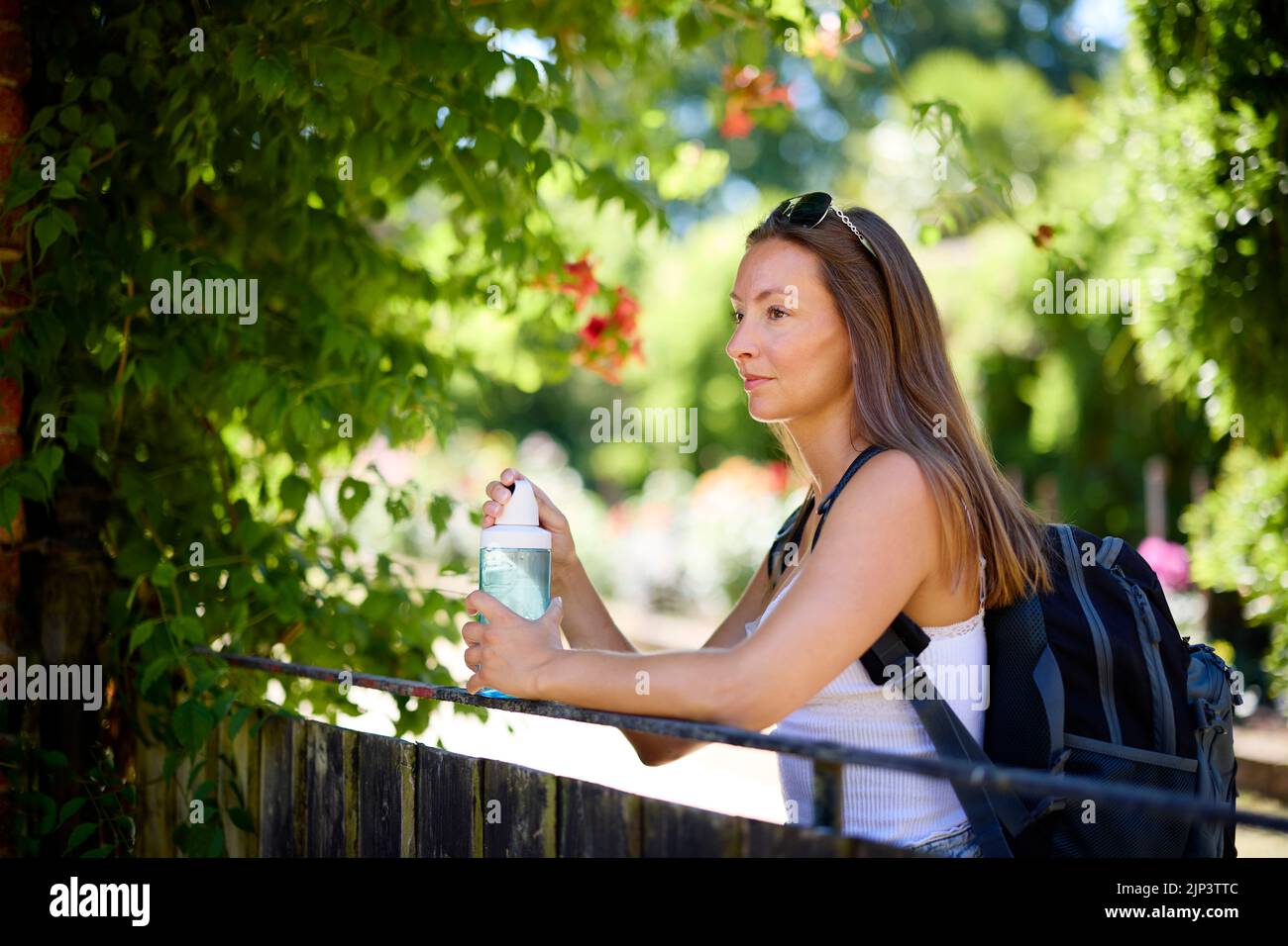 Woman relaxing outdoors with bottle of water Stock Photo