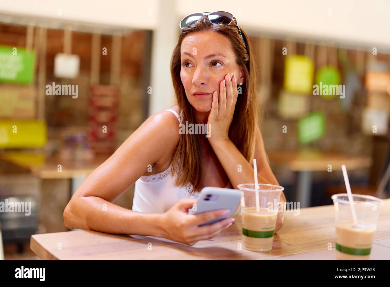 Woman looking shocked looking at message Stock Photo
