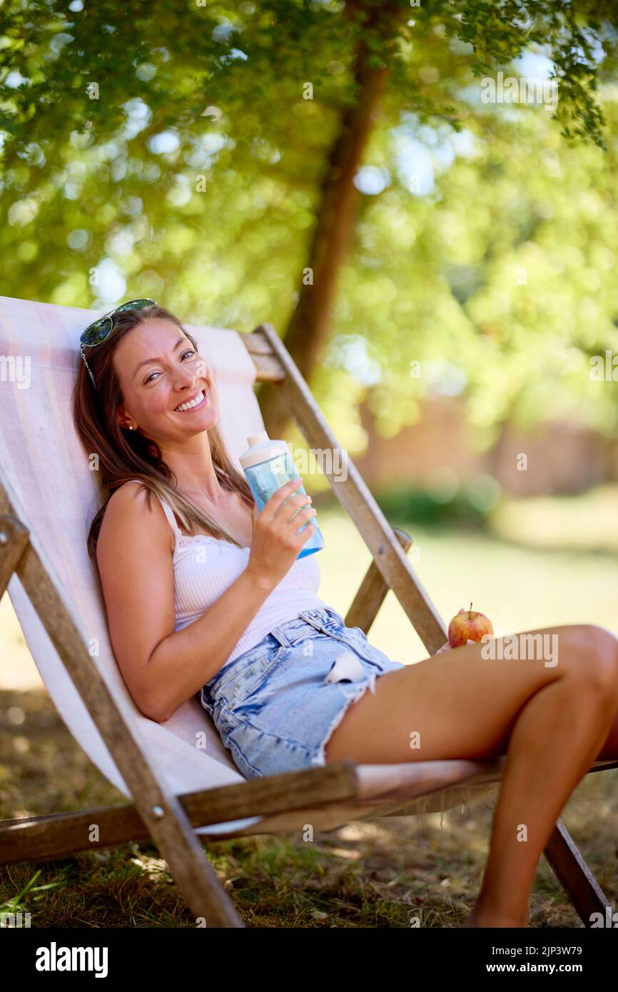 Attractive woman sat relaxing outdoors Stock Photo