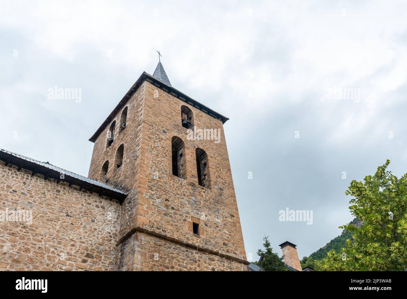 A low-angle shot of a church in the village of Panticosa against a cloudy sky Stock Photo