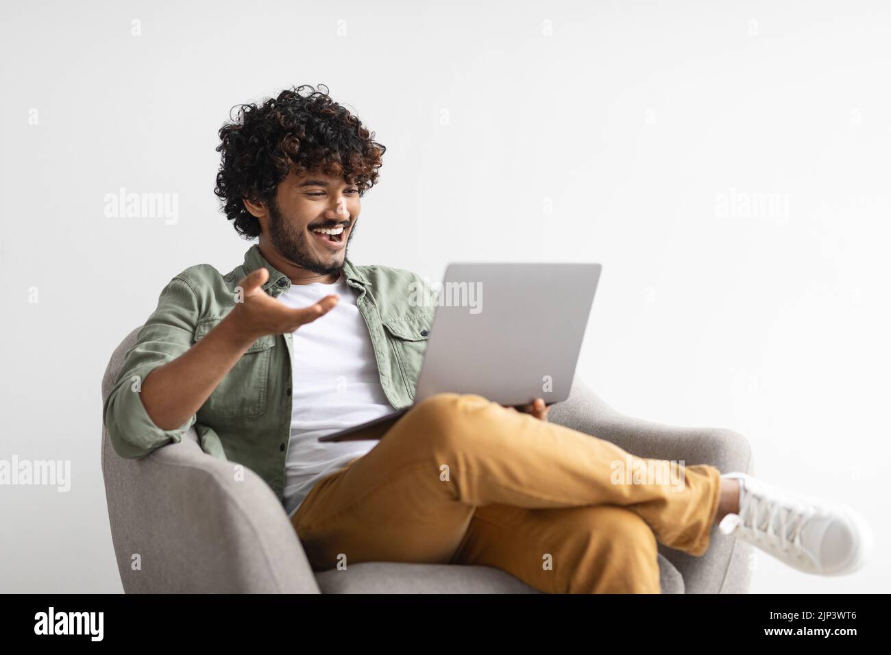 Relaxed eastern guy having video call, using computer Stock Photo