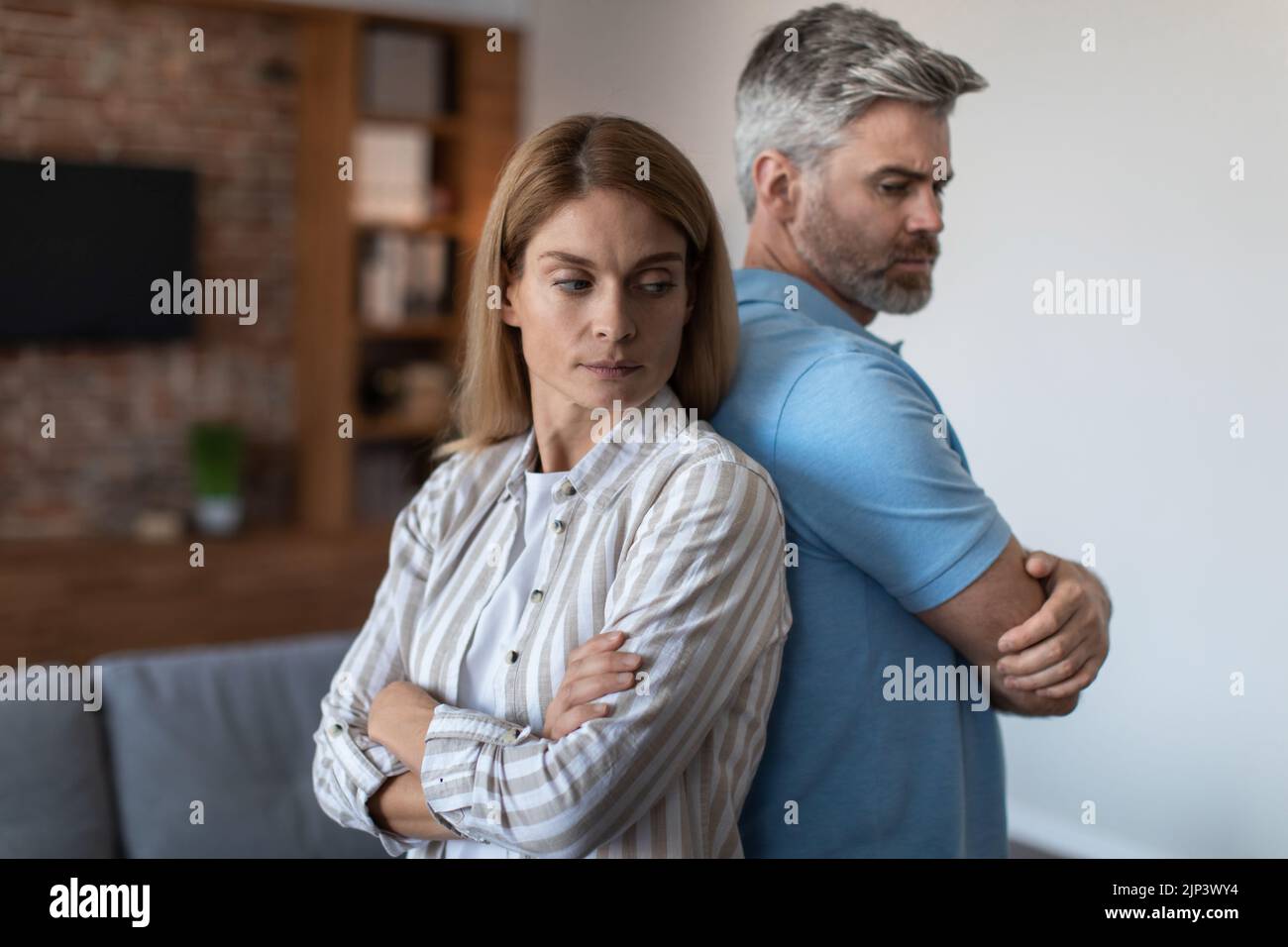 Offended upset adult european husband ignores wife, man and woman stand back to back in room interior Stock Photo