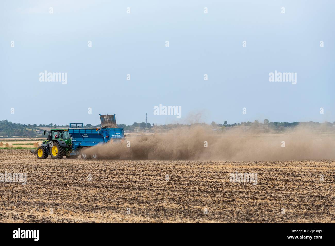 Aldreth, Cambridgeshire, UK. 15th Aug, 2022. A farmer spreads lime on an arable field making the most of the dry weather before thunder storms and rain are forecast across much of the UK. The arid conditions causes dust to fly and the UK weather is forecast to cool down with periods of rain. Credit: Julian Eales/Alamy Live News Stock Photo