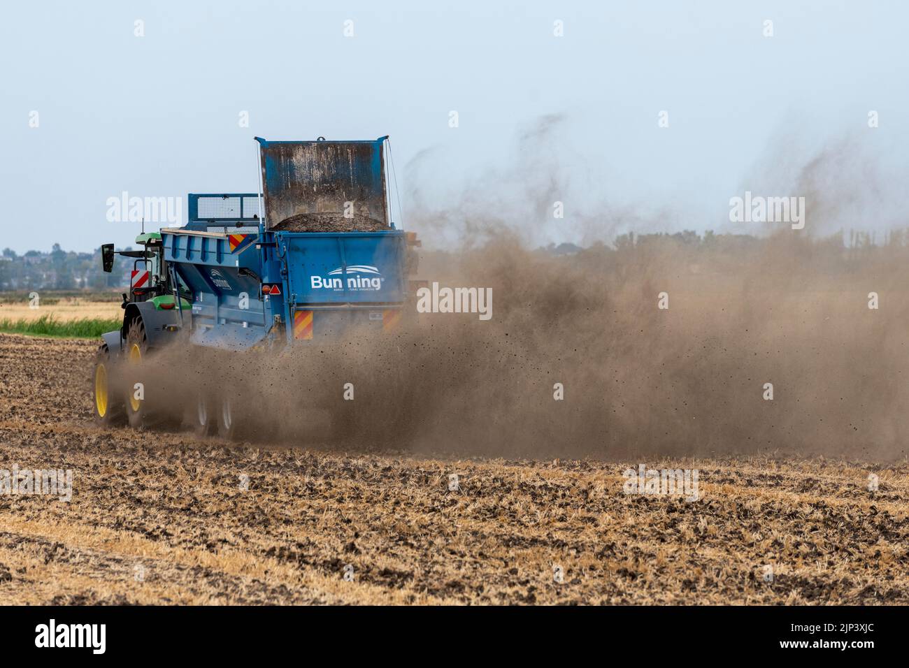 Aldreth, Cambridgeshire, UK. 15th Aug, 2022. A farmer spreads lime on an arable field making the most of the dry weather before thunder storms and rain are forecast across much of the UK. The arid conditions causes dust to fly and the UK weather is forecast to cool down with periods of rain. Credit: Julian Eales/Alamy Live News Stock Photo