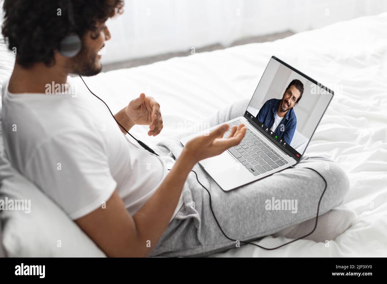 Indian guy having video call with his friend, using laptop Stock Photo