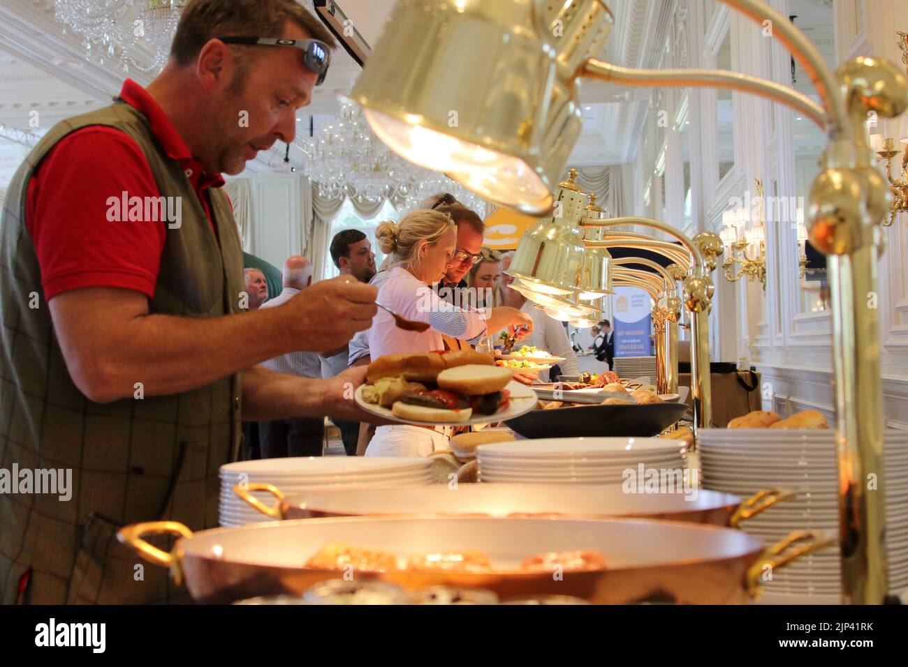 Trump Turnberry Hotel, Ayrshire, Scotland, UK. Diners at a corporate event select food kept warm under heat lamps Stock Photo