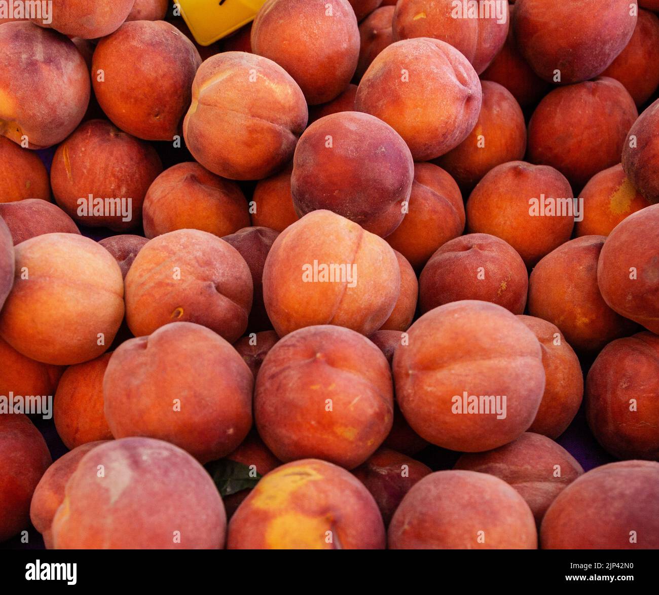 Peach pile. Close up of ripe peaches at a Farmer's Market.  Selective focus. Stock Photo