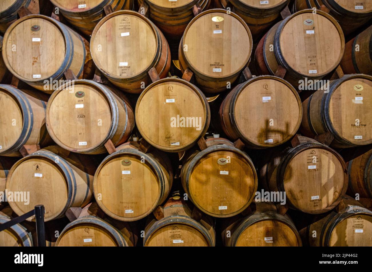 Oak barrels filled with ageing wine at a winery in The Napa Valley, California, USA Stock Photo