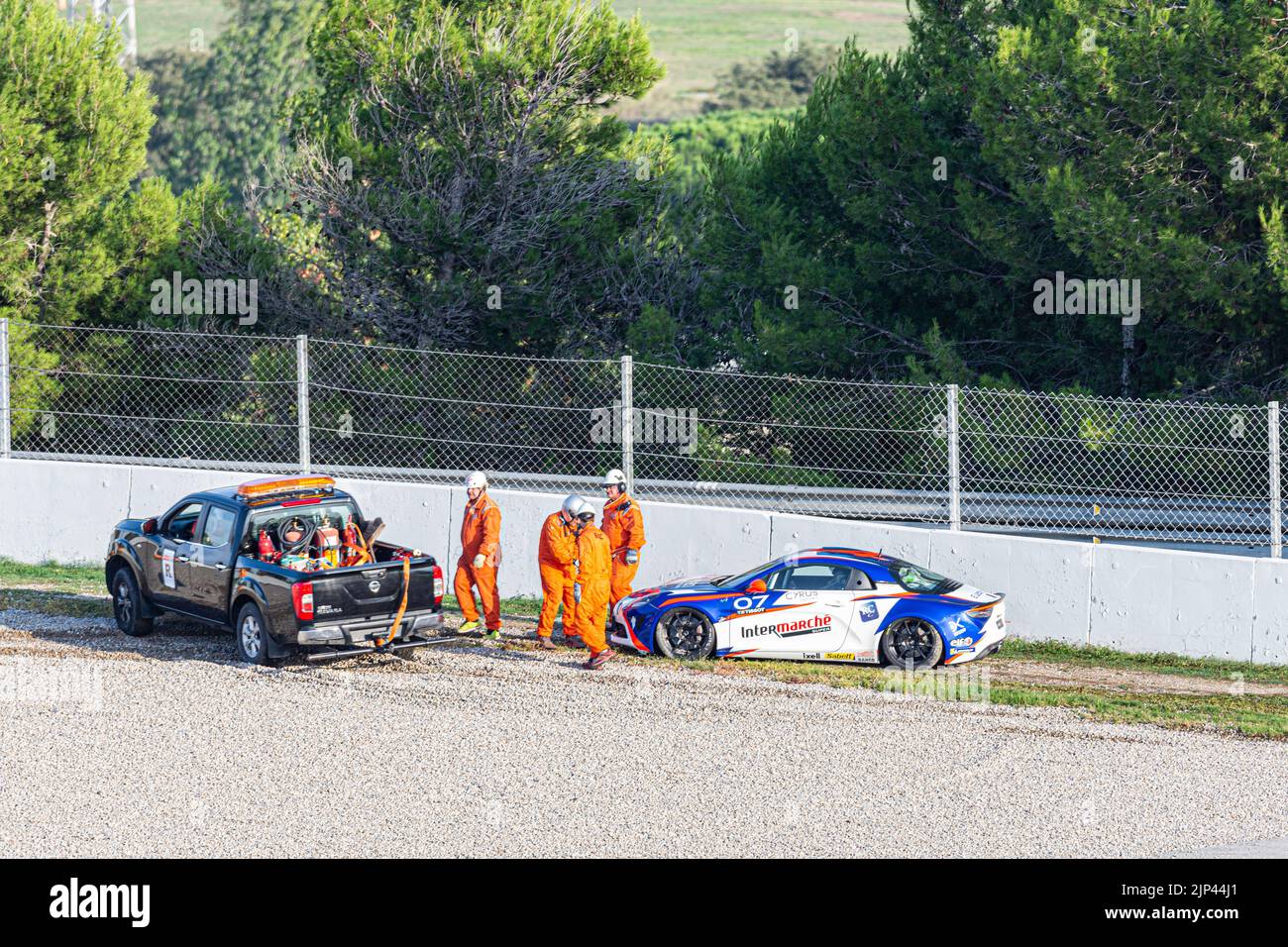 A car towing a racing car that has gone off the track Stock Photo