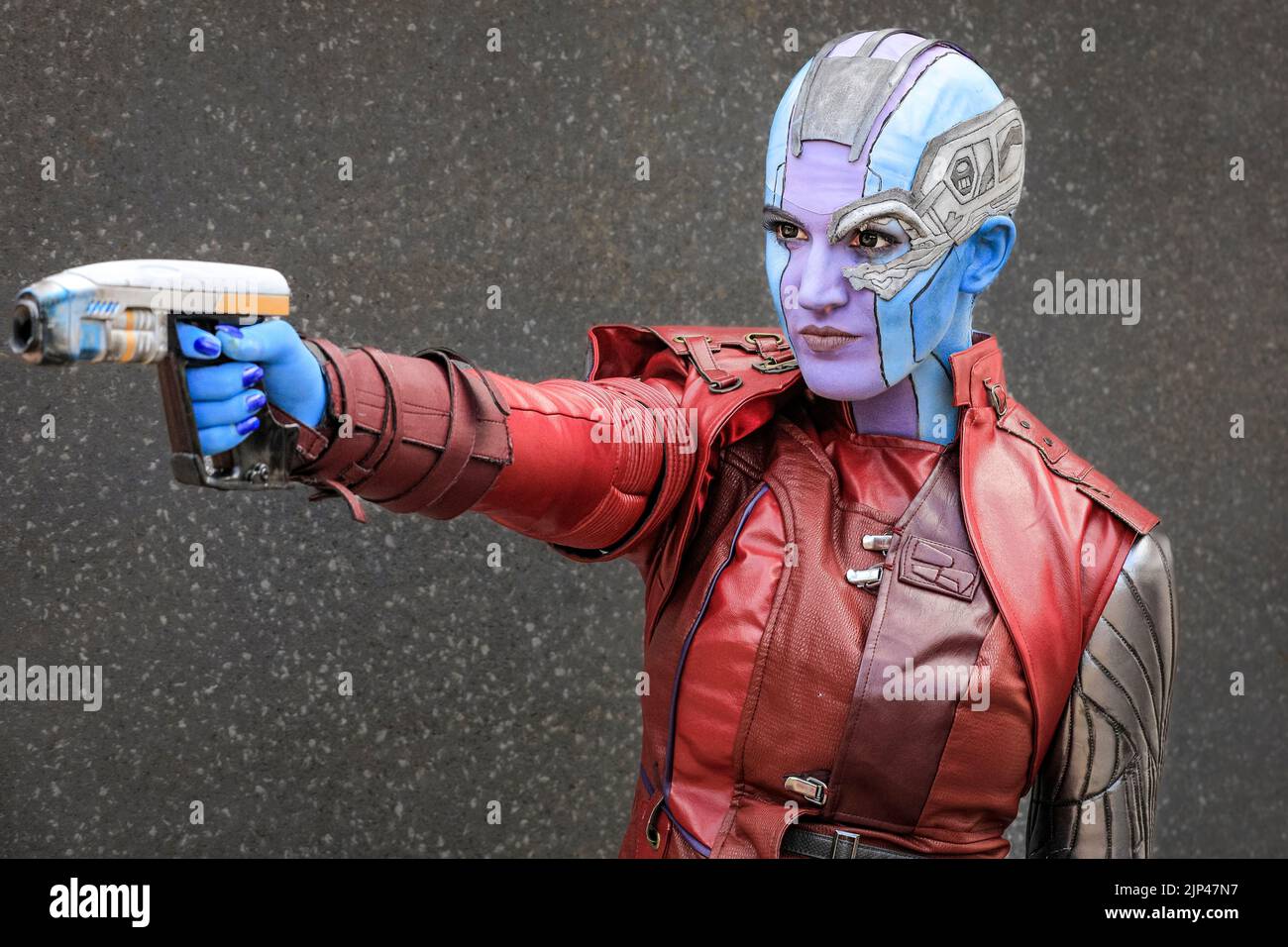 Young female cosplayer poses in costume as Harley Quinn from Batman, MCM London Comic Con Stock Photo