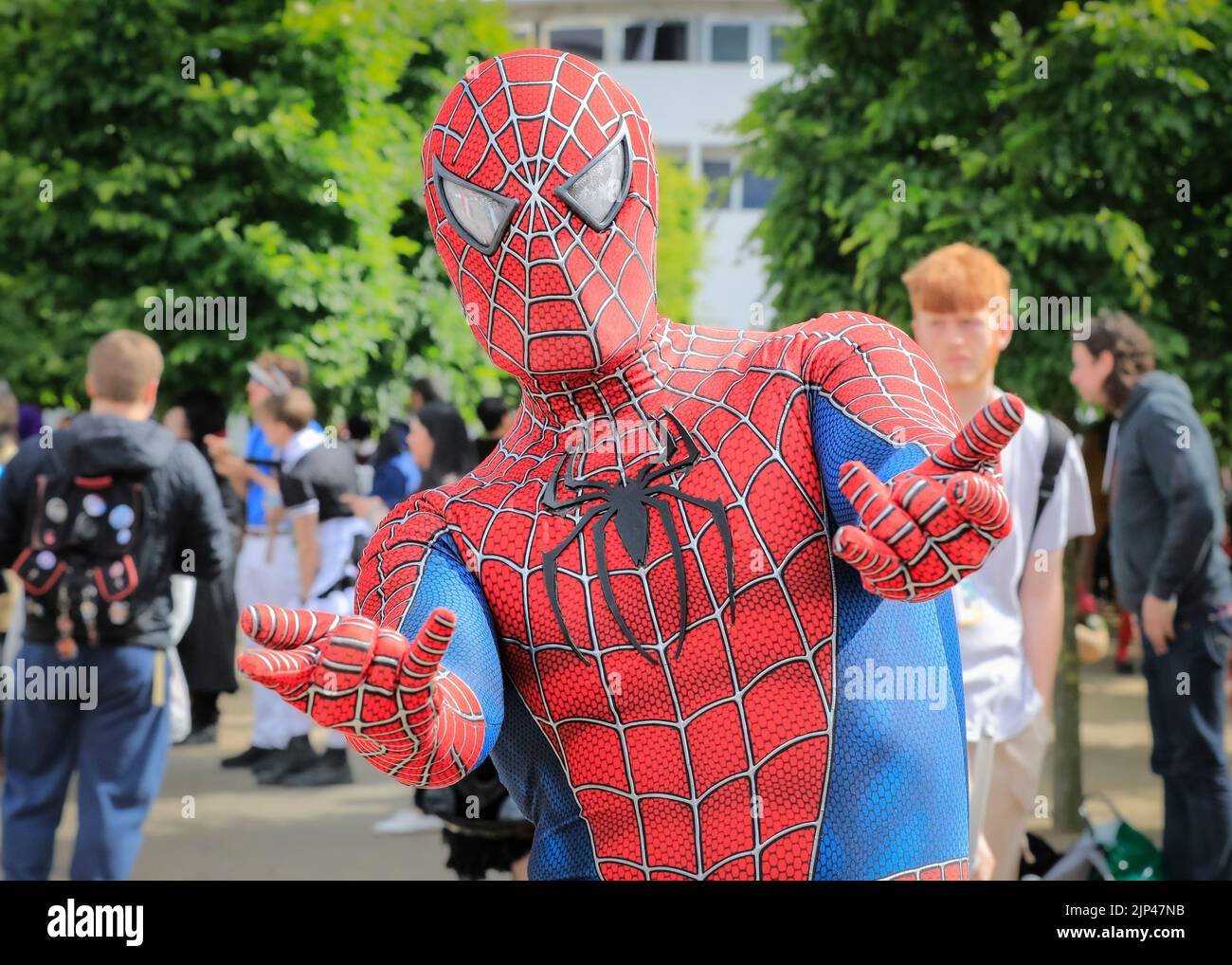 Cosplayer in Spiderman costume, visitors in outfits at Comic Con London, UK Stock Photo
