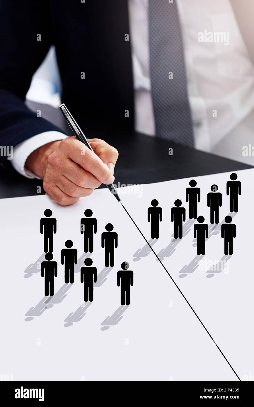 Which side are you on. a businessman drawing a dividing line between two groups of people. Stock Photo