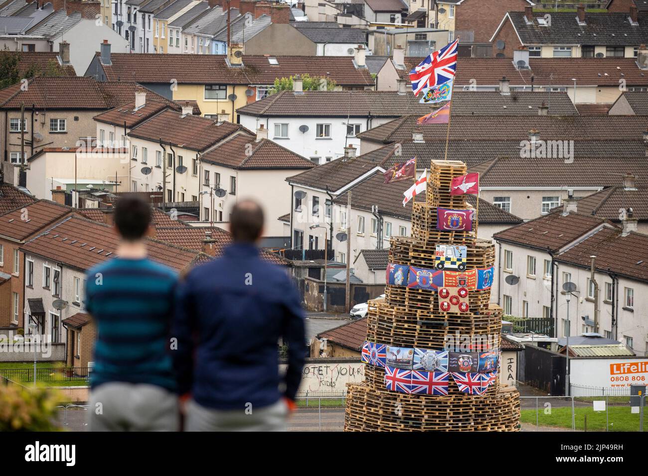 People view a bonfire stack prior to it being lit to mark the Catholic Feast of the Assumption in the Bogside area of Londonderry, Northern Ireland. Picture date: Monday August 15, 2022. Stock Photo