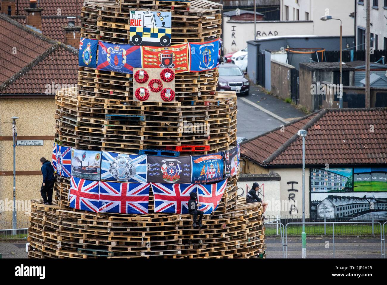 Young boys climb around a bonfire prior to it being lit to mark the Catholic Feast of the Assumption in the Bogside area of Londonderry, Northern Ireland. Picture date: Monday August 15, 2022. Stock Photo