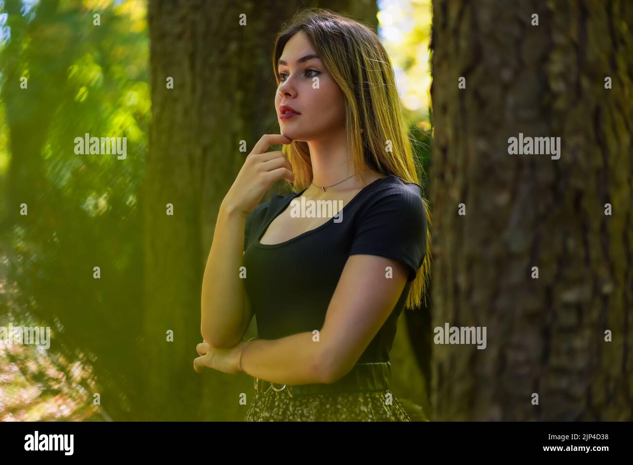 A close-up shot of a Caucasian brunette woman posing under a tree Stock ...