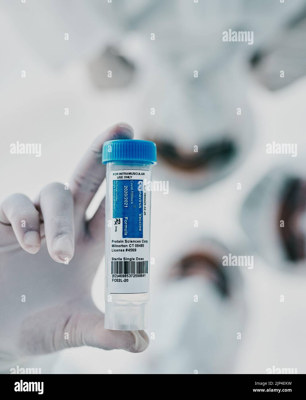 Covid, scientists and vaccine vial while a group medical practitioners, chemists and researchers stand together from below. Innovation cure, treatment Stock Photo
