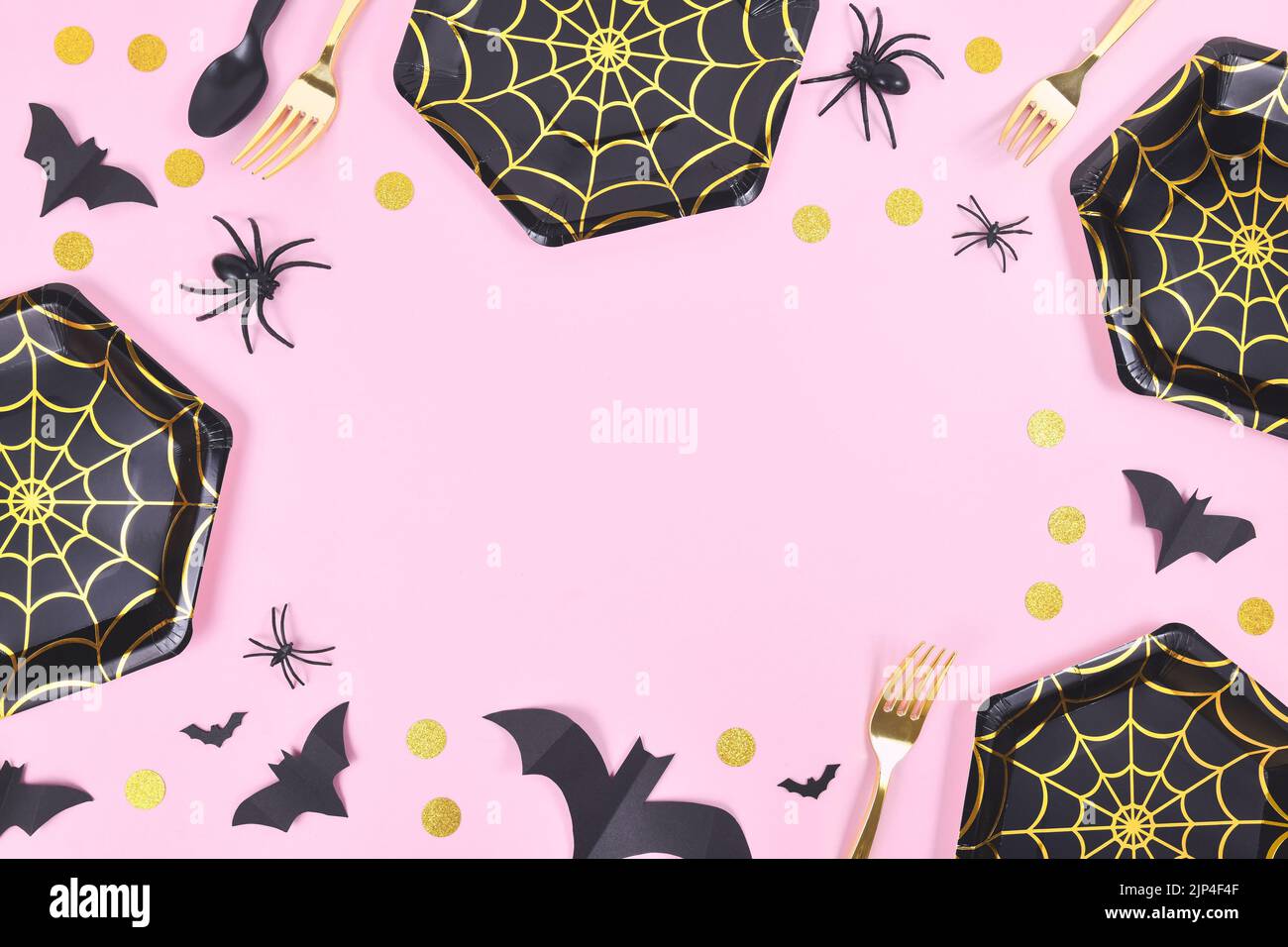 Halloween party frame with black and gold spider web plates, spiders and confetti on pink background Stock Photo