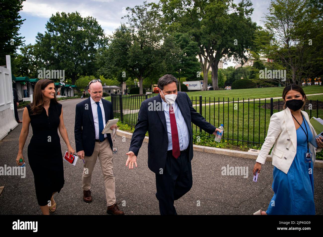 Ron Klain, White House chief of staff, center, reacts to questions from Kaitlan Collins, chief White House correspondent for CNN, left, and Jeff Mason, White House correspondent for Reuters, as he returns to the West Wing with Remi Yamamoto, White House senior advisor for communications for the White House chief of staff, right, following a television interview on the North Lawn of the White House in Washington, DC, US, on Monday, Aug. 8, 2022. US President Joe Biden resumed official travel today for the first time since his bout with Covid-19, traveling to Kentucky to show federal support f Stock Photo