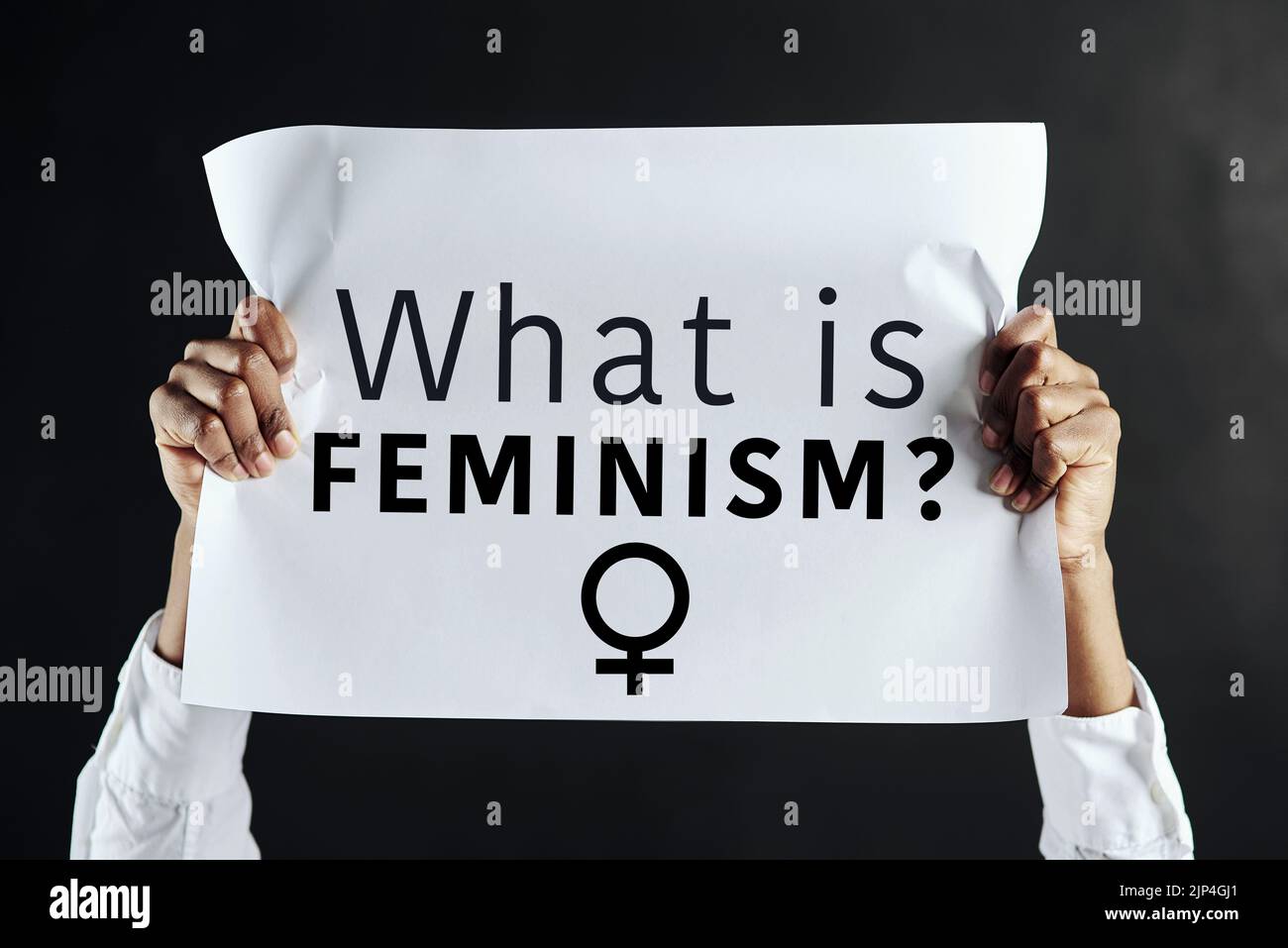 The question on everybodys lips. Studio shot of an unrecognisable woman holding up a sign with the words What is feminism on it. Stock Photo
