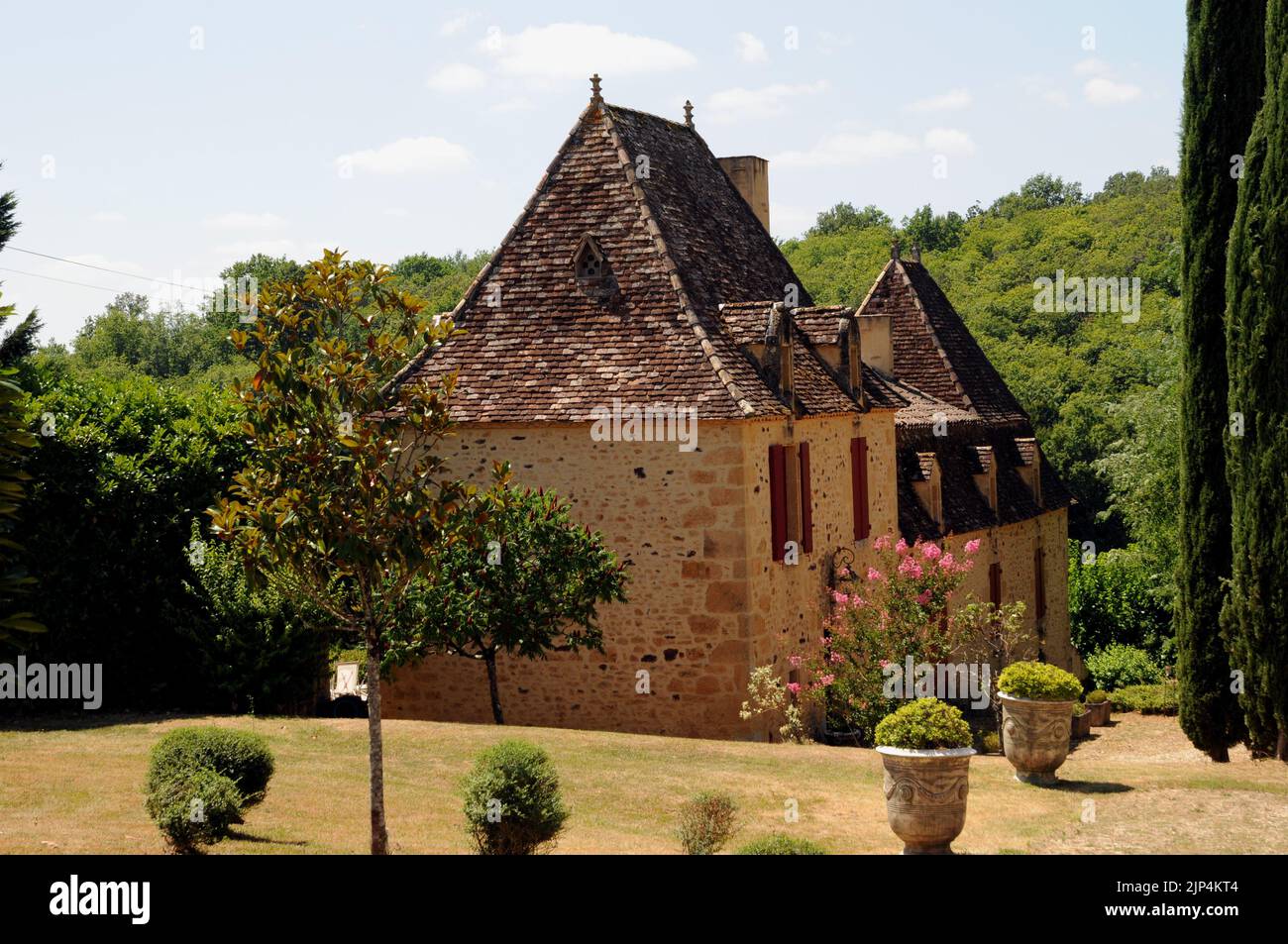 A fine example of a country house in the Perigord Noir region of the Dordogne. It is built of honey coloured stone with a steeply pitched roof. Stock Photo