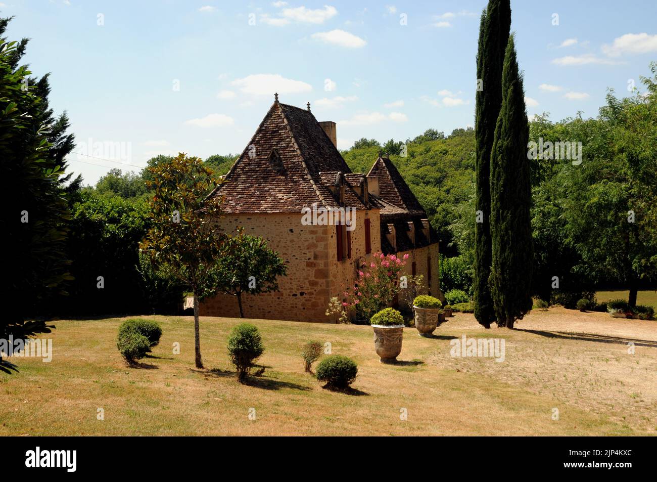 A fine example of a country house in the Perigord Noir region of the Dordogne. It is built of honey coloured stone with a steeply pitched roof. Stock Photo