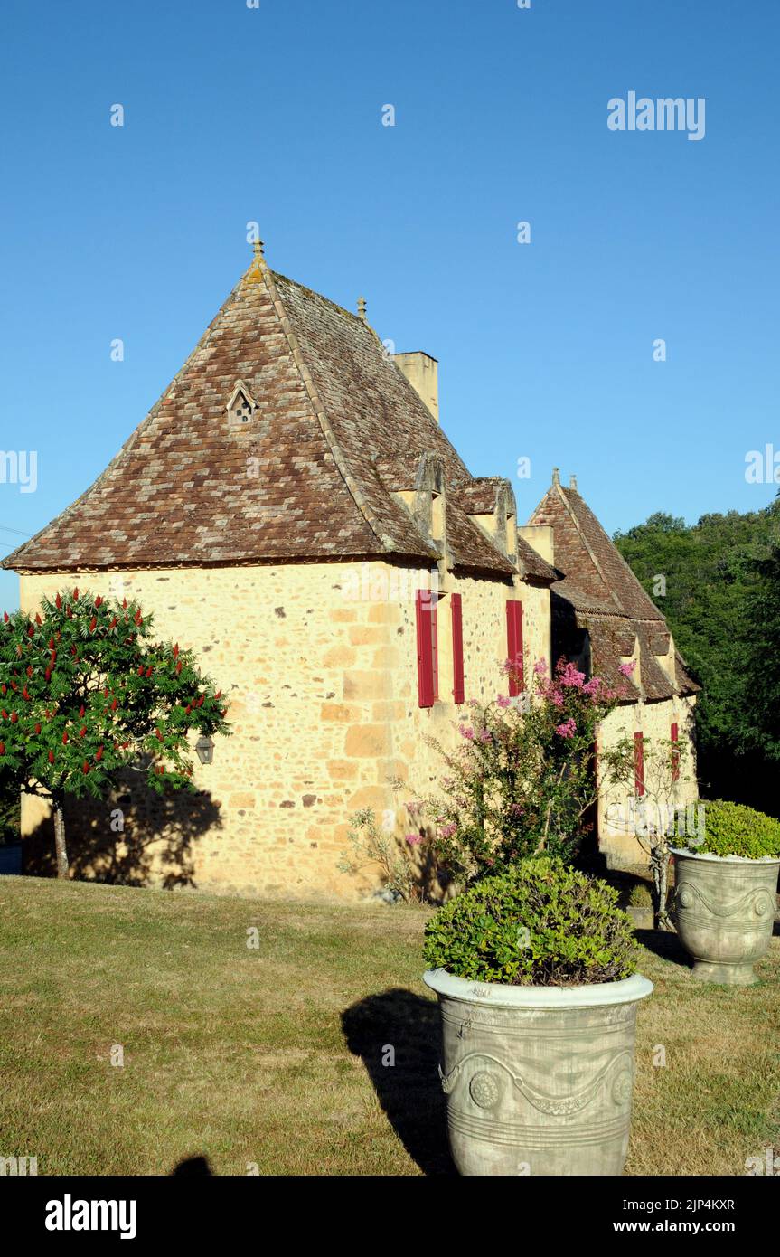 A fine example of a country house in the Perigord Noir region of the Dordogne. It is built of honey coloured stone with a steeply pitched roof. Stock Photo